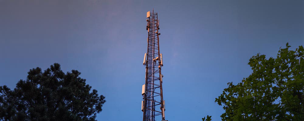 Radiomast fotograferad mot blå himmel.